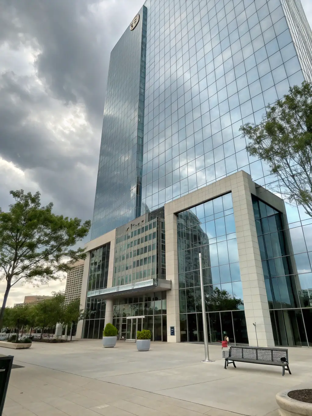 An exterior shot of a modern office building with glass facade, reflecting the sky, demonstrating Proobra.es's capabilities in commercial construction.